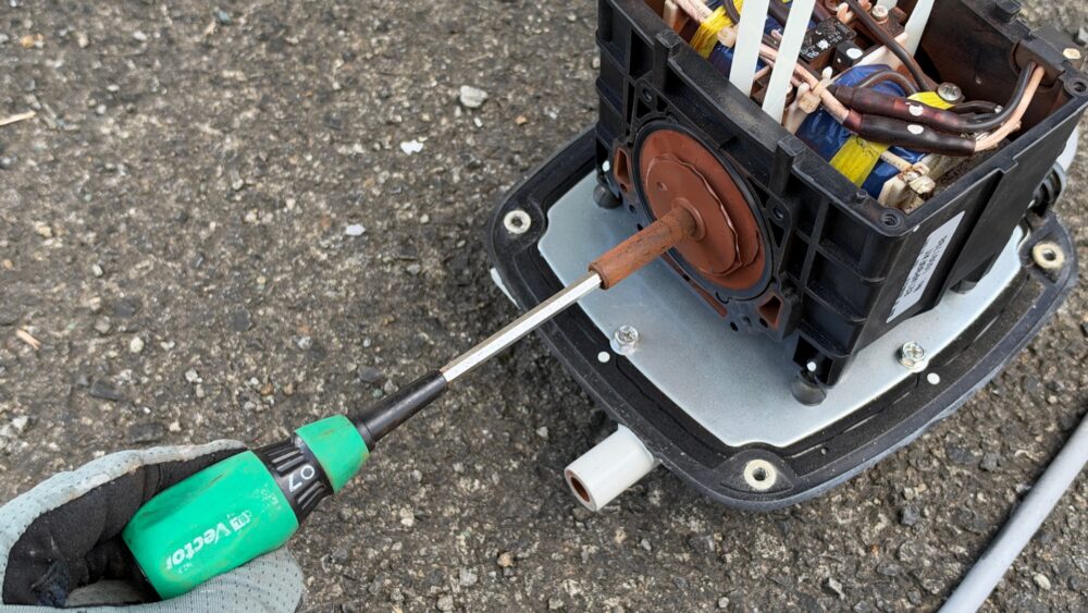 ナットドライバーでUロックナットを外す様子
